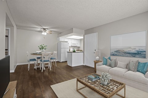 A living room with a couch, a dining table, and a television.