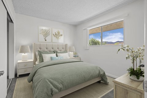 A bedroom with a large bed and a window overlooking a mountainous landscape.