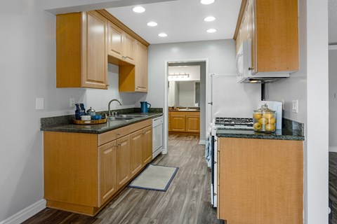 A kitchen with wooden cabinets and granite countertops.