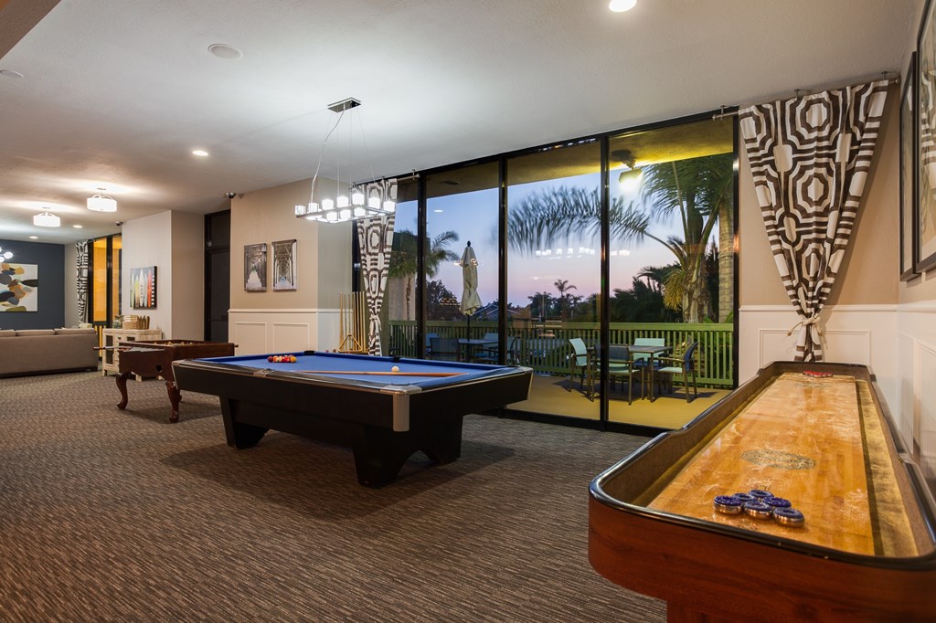 A pool table in a room with a view of the outside.