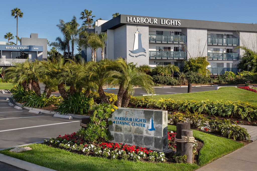 A sign for "Harbour Lights Resort Apartments" on the side of the apartment building.