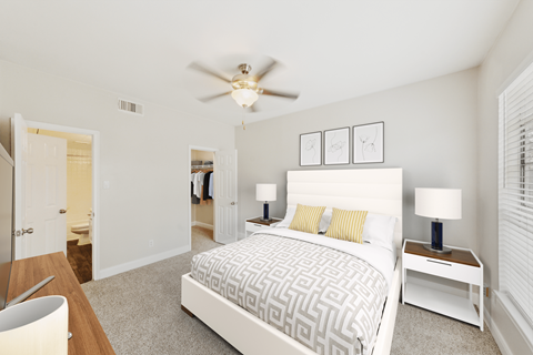 A bedroom with a large bed and a ceiling fan.