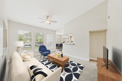 A living room with a white couch and a blue chair.