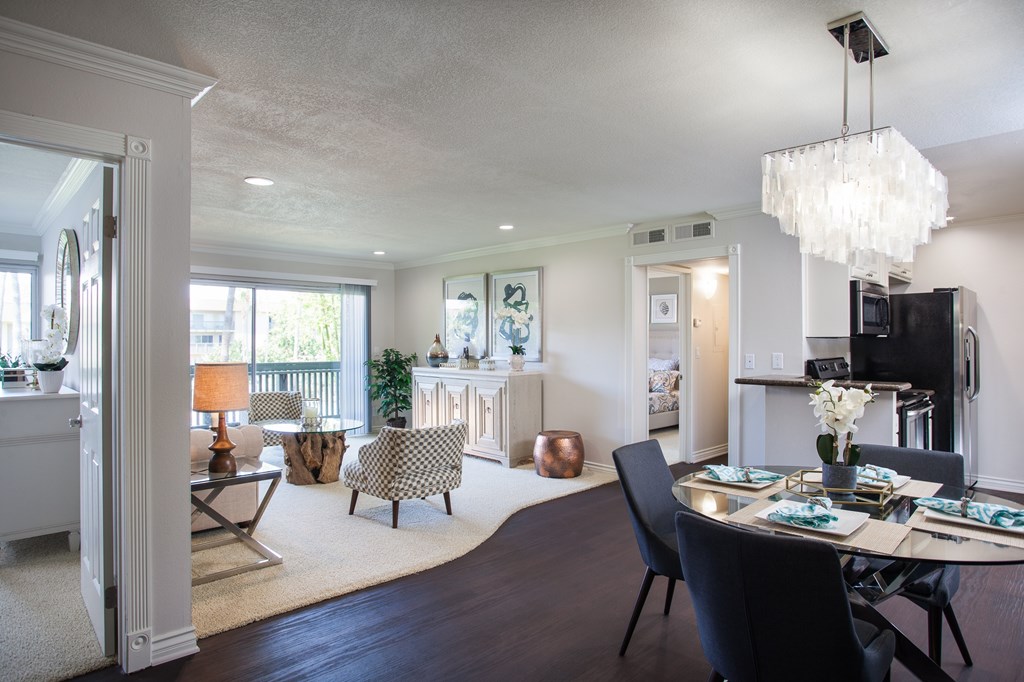 A modern living and dining room with a large table and chairs.