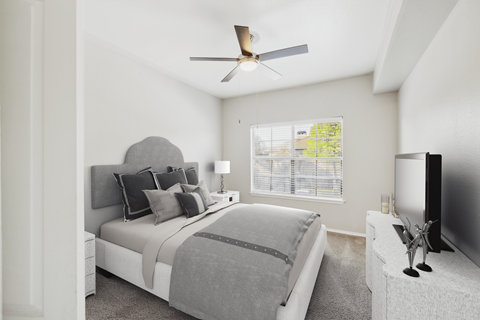 A bedroom with a large bed and a television on a stand.