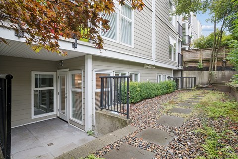 A house with a grey siding and a black gate.