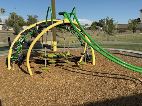 A playground with a green and yellow slide.