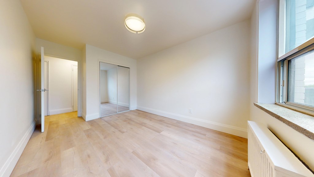 A room with a window and a radiator on the wall.
