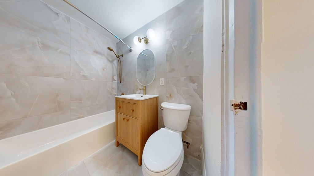A white toilet sits next to a bathtub in a bathroom.