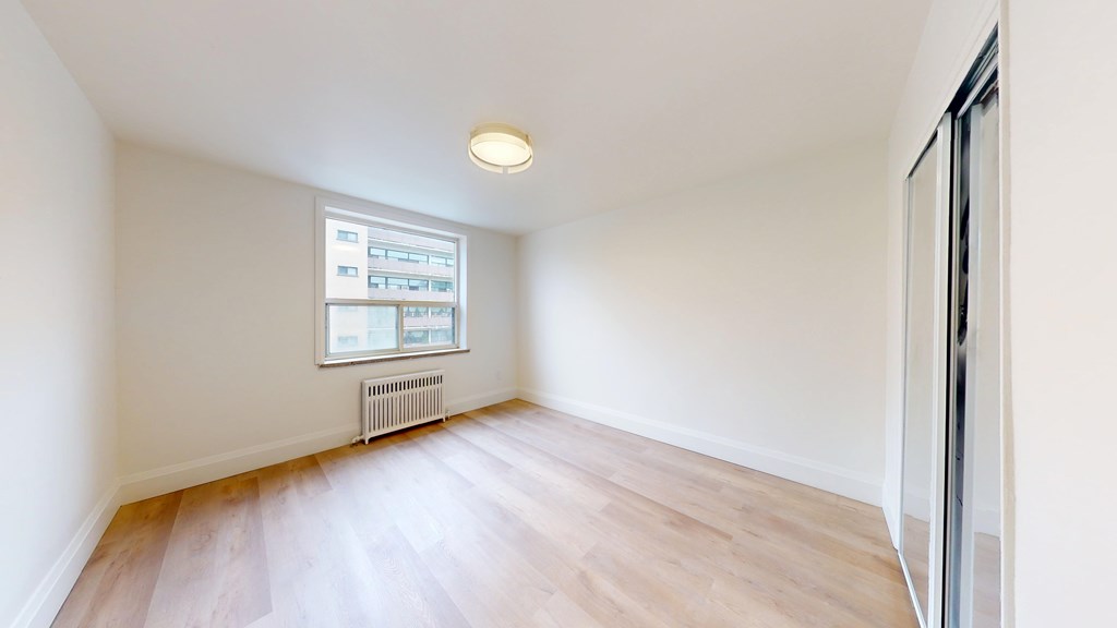 A room with a window and a radiator on the wall.