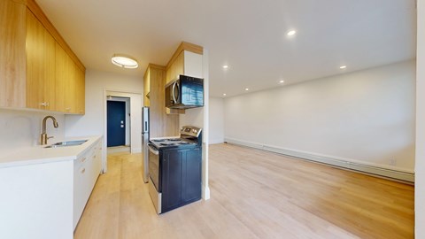 A kitchen with wooden cabinets and a black fridge.