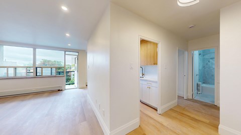 A spacious room with a large window and a door leading to a balcony.