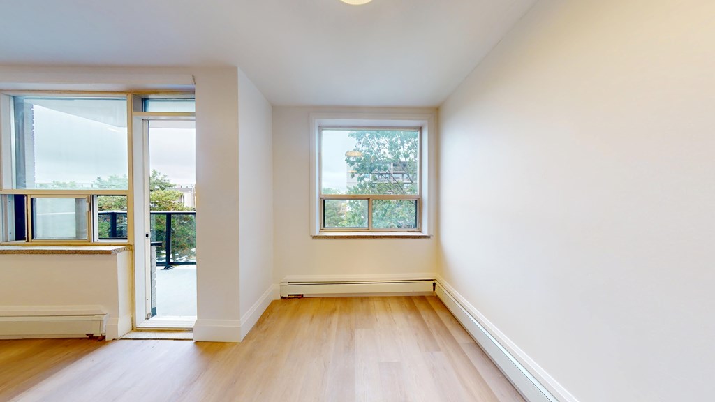 A room with a window and a door leading outside.