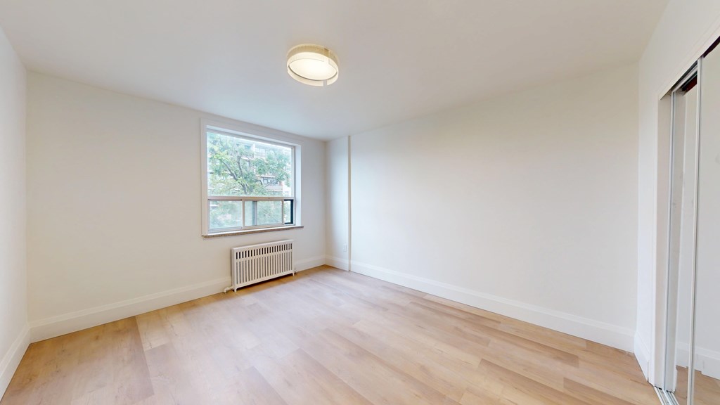 A room with a window and a radiator on the wall.