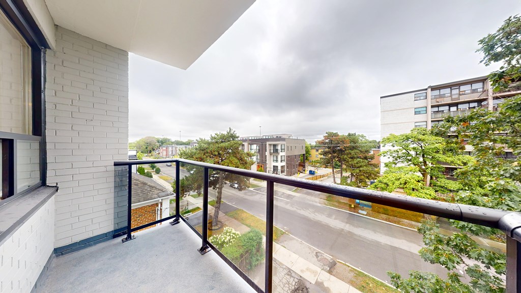 A balcony with a view of a road and buildings.