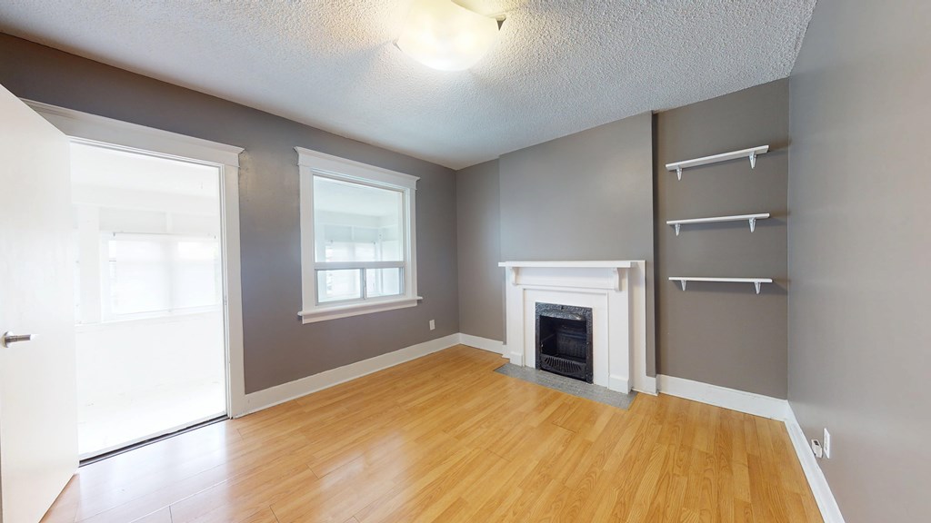 A room with a fireplace and a window.