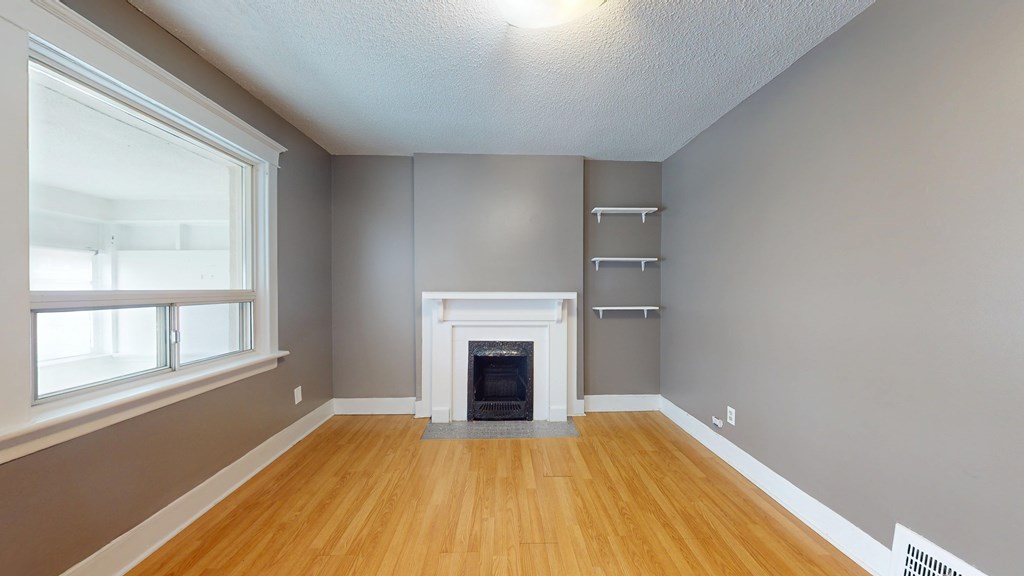 A room with a fireplace and a window.