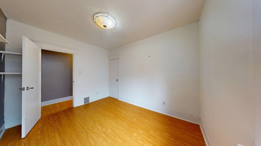 A room with a wooden floor and a ceiling light.