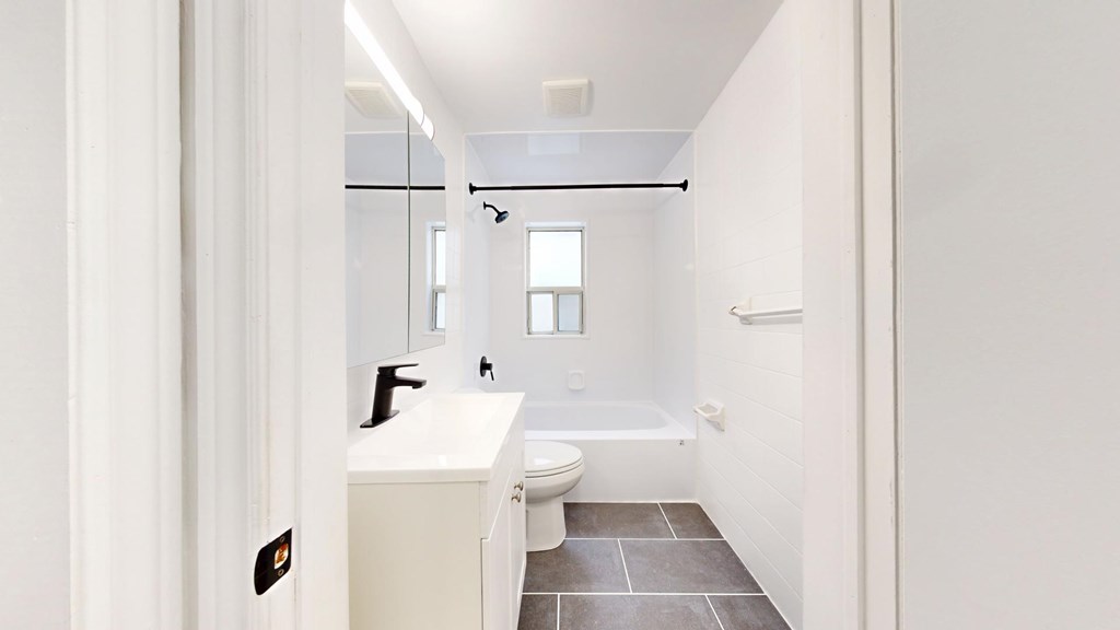 A white bathroom with a toilet, sink, and bathtub.