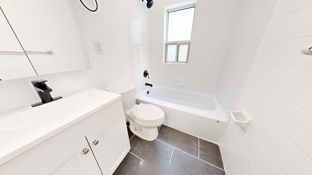 A white bathroom with a toilet, sink, and tub.