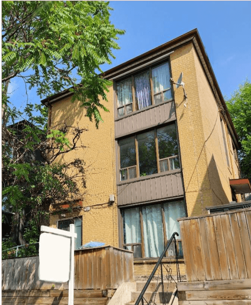 A brown building with a white door and windows.