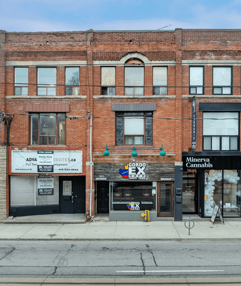 A red brick building with a store front that says Gordo Ex.