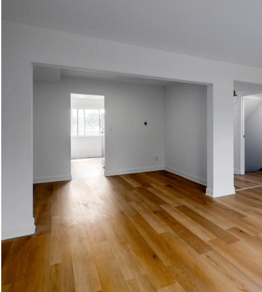 A room with wooden flooring and white walls.