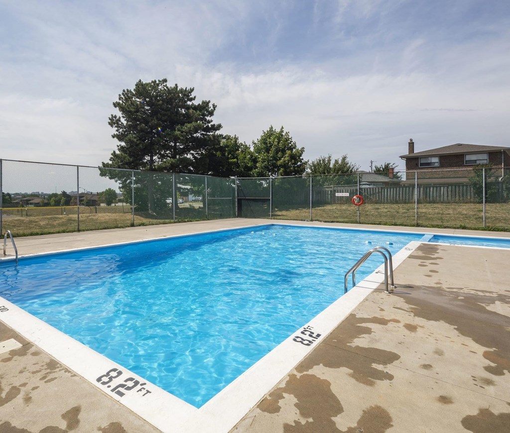 A blue swimming pool with a white edge and a brownish floor.