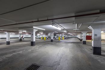 A parking garage with concrete floors and white pillars.