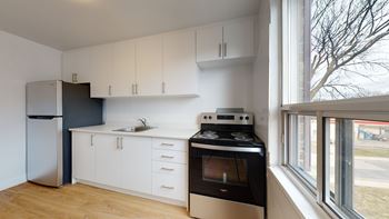 A kitchen with white cabinets and a black stove top oven.