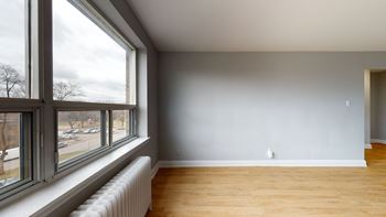 A room with a large window and a radiator on the wall.