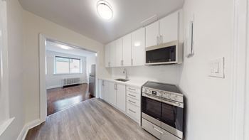 A kitchen with white cabinets and a microwave above the stove.