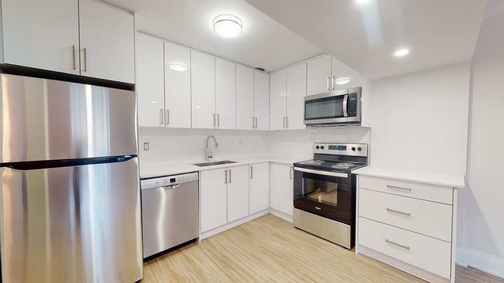 A modern kitchen with stainless steel appliances and white cabinets.