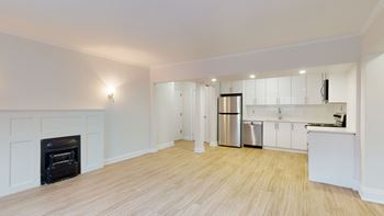 A modern kitchen with a stainless steel refrigerator and a fireplace.