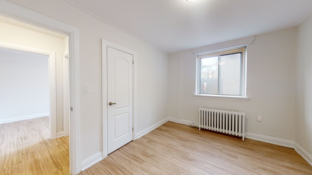 A room with a window and a radiator on the wall.