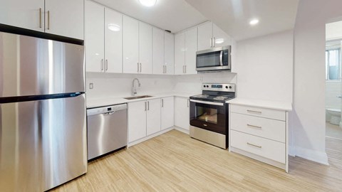 A modern kitchen with stainless steel appliances and white cabinets.