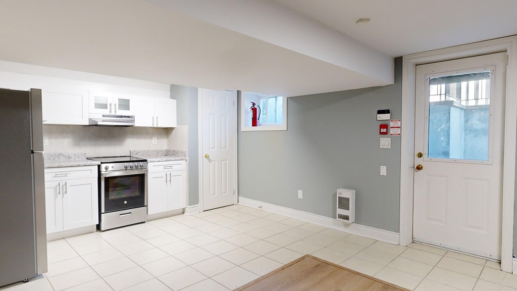 A kitchen with a refrigerator, oven, and microwave.