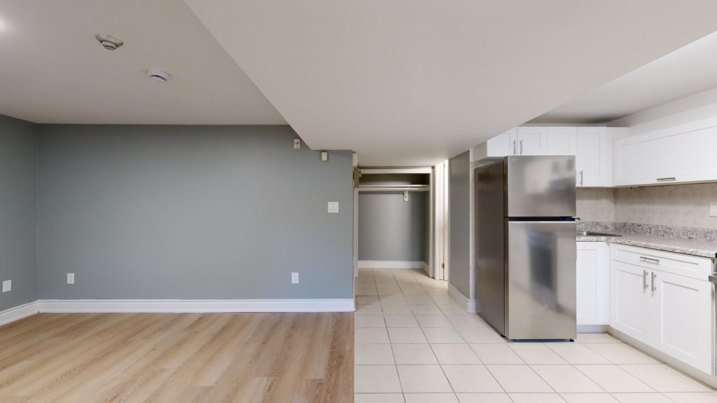 A kitchen with a refrigerator, oven, and cabinets.