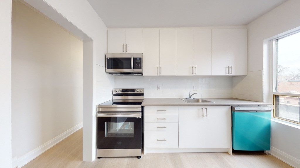 A kitchen with white cabinets and a black oven.
