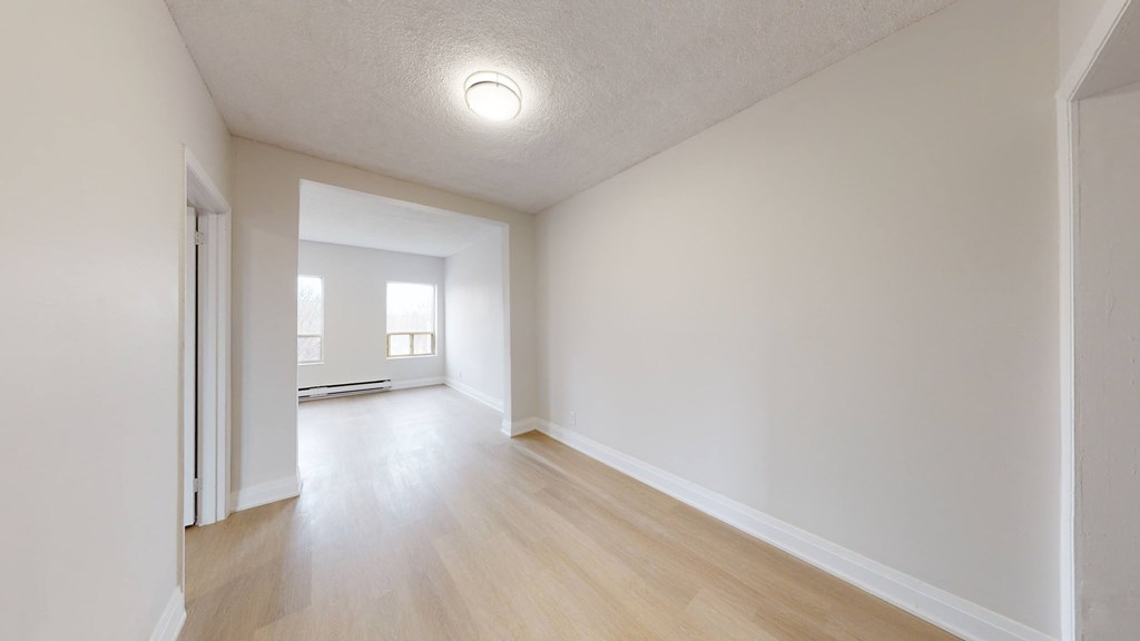 A room with a white ceiling and wooden floor.