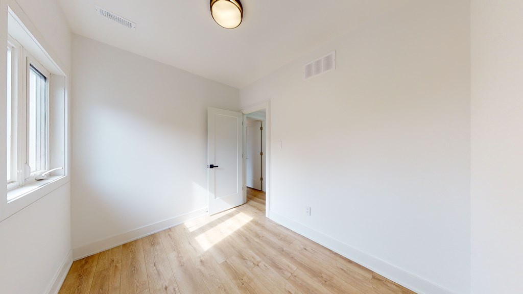 A room with a wooden floor and white walls.