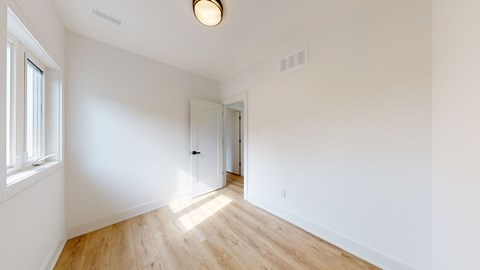 A room with a wooden floor and white walls.