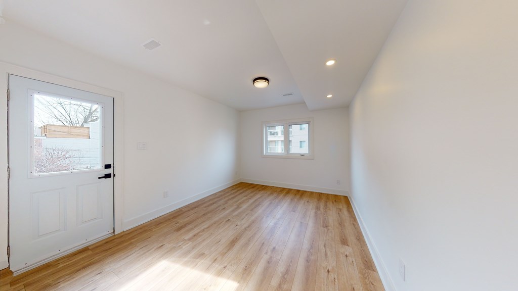 A room with wooden flooring and white walls.