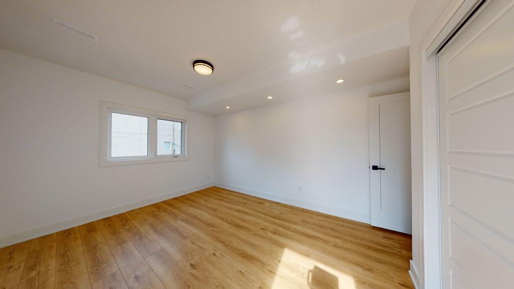 A room with wooden flooring and a window.
