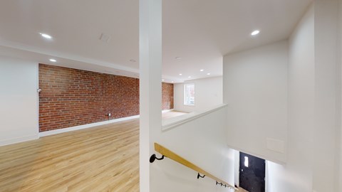 A room with a brick wall and wooden flooring.