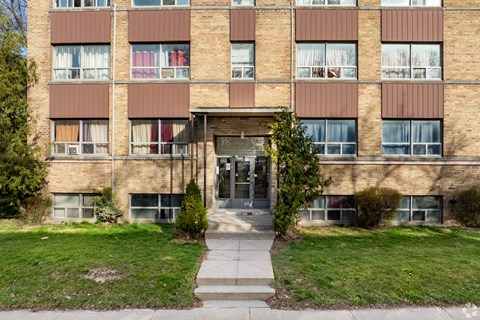 A brick building with a green lawn in front.