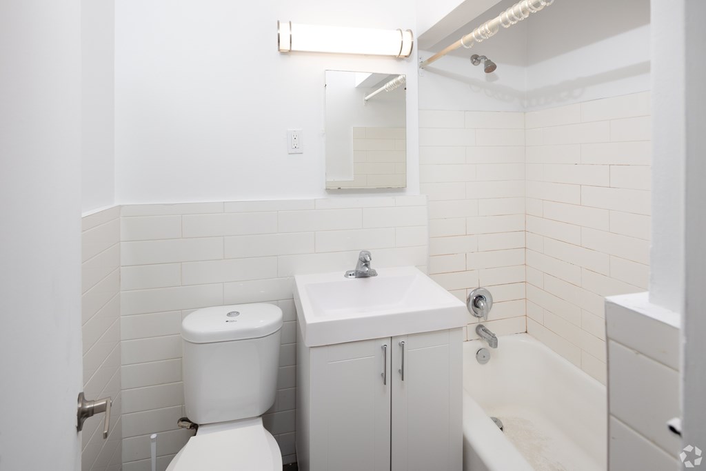 A white toilet sits next to a sink in a small bathroom.