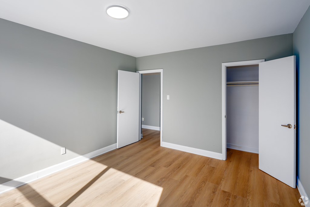 A room with a white door and a white cabinet with a light on the ceiling.
