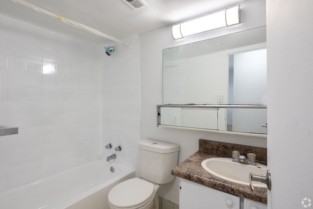 A white toilet sits next to a sink in a bathroom.