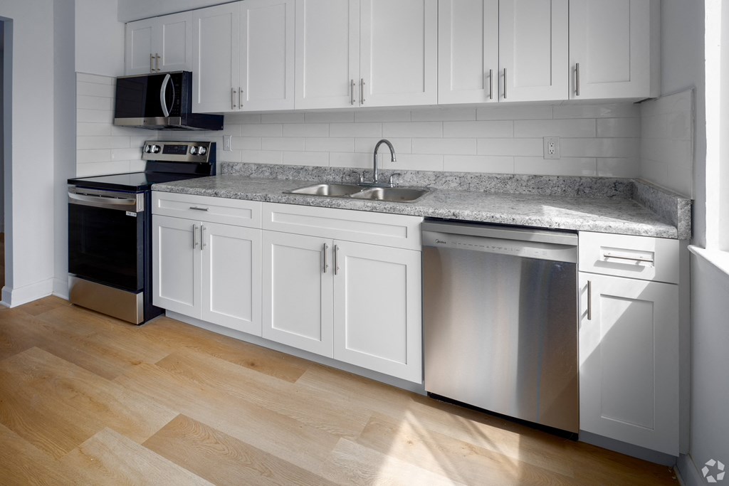A kitchen with white cabinets and a granite countertop.
